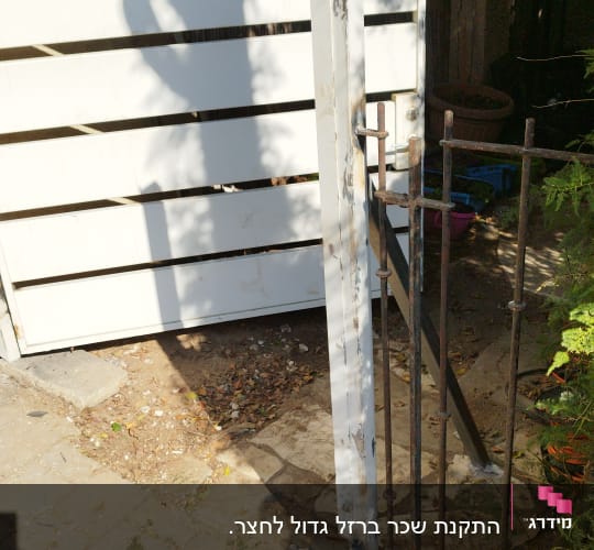 שער מתכת לבן עם מסגרת ברזל חלודה